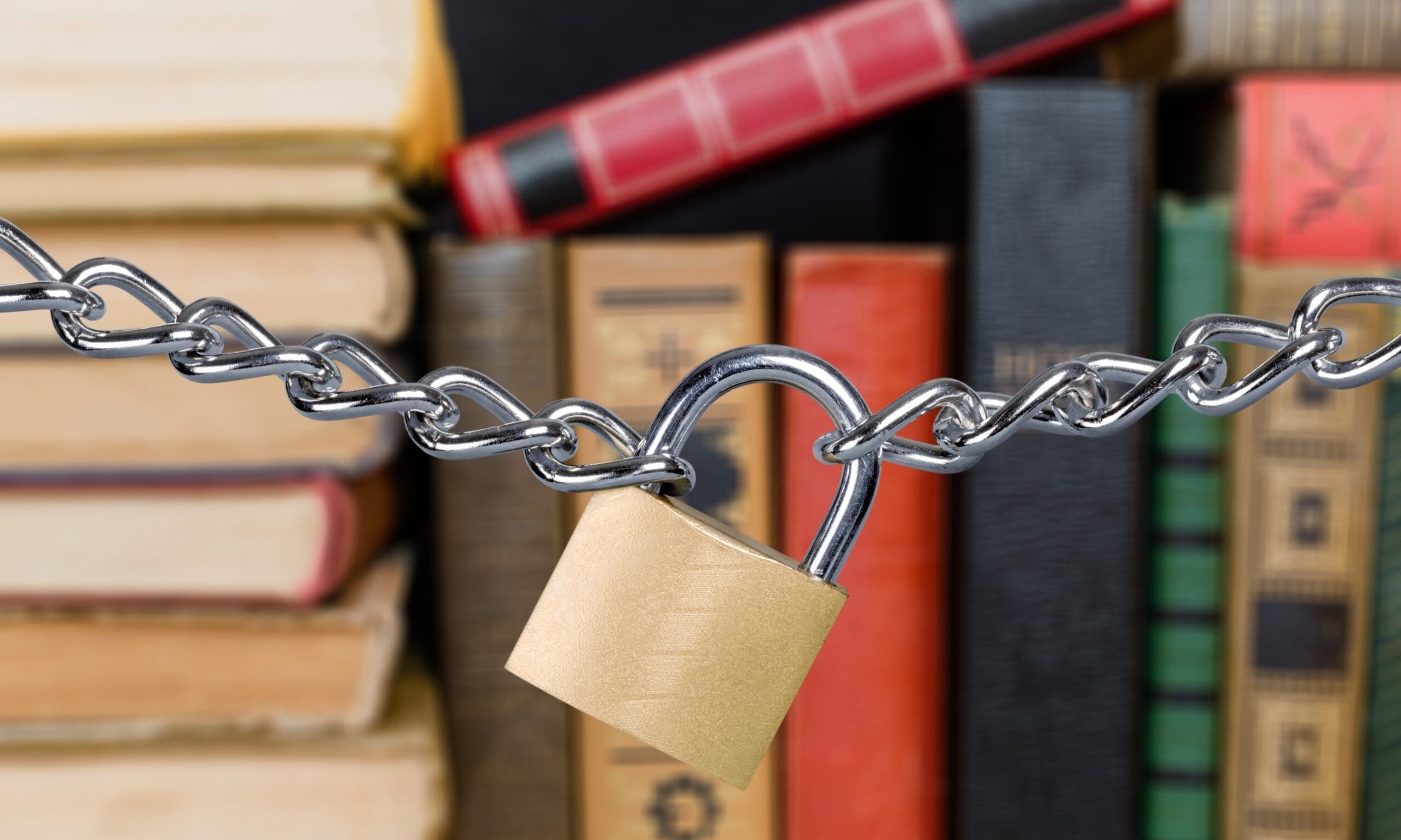 Image of books on shelf with a lock and chain keeping them in place.